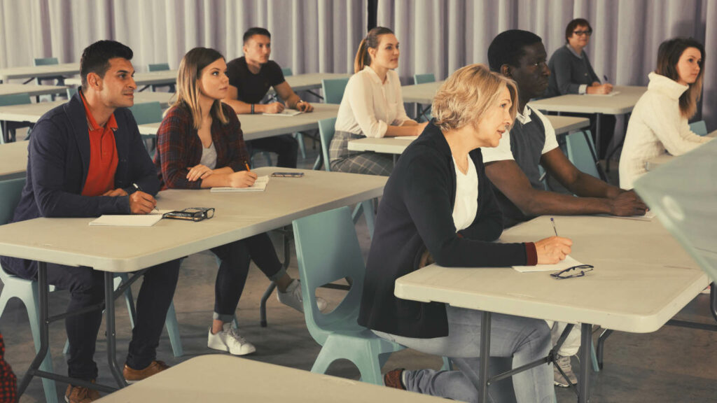 A classroom of people taking notes